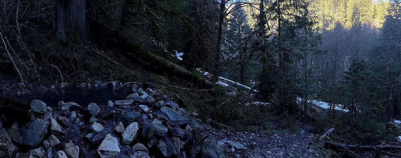 Rock-lined spring pool above the trail at Olympic Hot Springs (archive photograph)